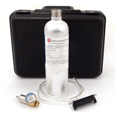 A silver gas cylinder labeled "Calibration Gas" is positioned in front of a black protective case, accompanied by a pressure regulator with gauge, clear tubing, and a black bracket. These components make up the RKI Instruments Manual Calibration Kit for GX-2009 Monitor from PK Safety Supply, an essential set for calibrating gas monitors.