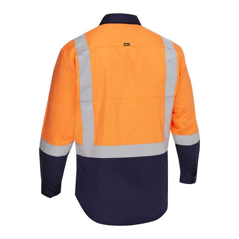The PIP Bisley Vented Work Shirt w/Navy Bottom 312M6367H features a bright orange top and navy blue bottom, with reflective tape on the back and sleeves. This long-sleeve shirt offers stylish safety and meets ANSI/ISEA 107 standards.