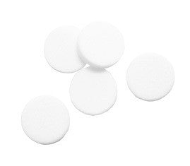 Five round, white tablets are scattered on a plain white background, resembling components from a BW Technologies by Honeywell GA-PFMAX-100 Pump Filter or intricate gas monitor parts.