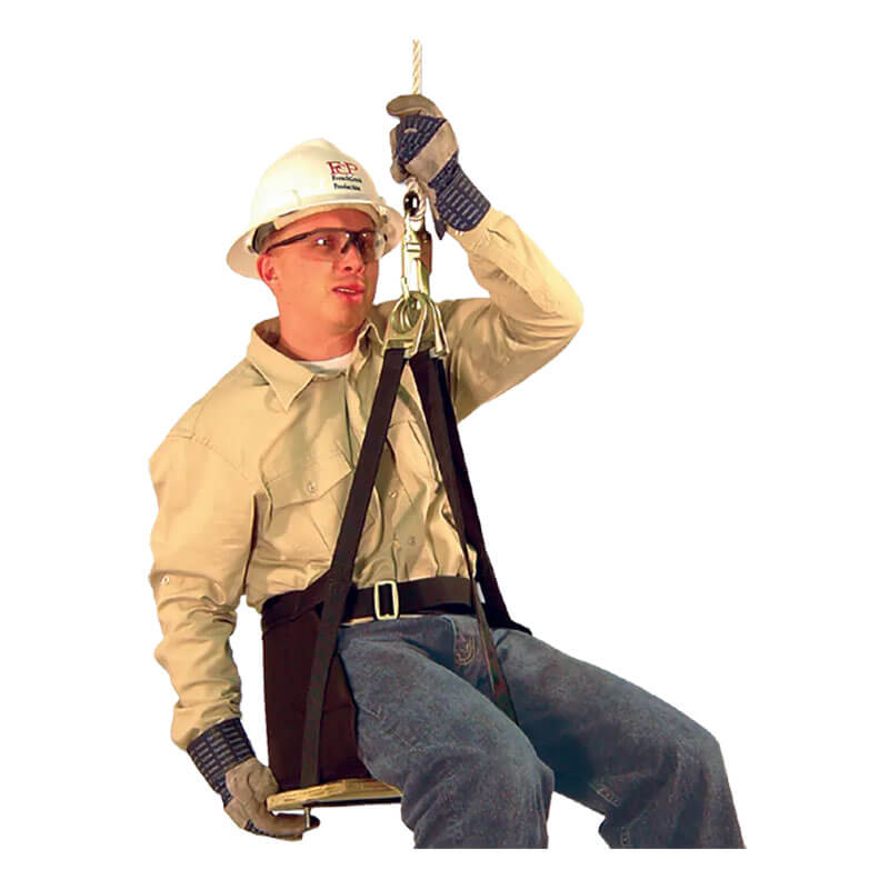 A construction worker in full safety gear sits on a French Creek Production Deluxe Work Seat 4153, suspended by rope, demonstrating correct use of fall protection equipment.