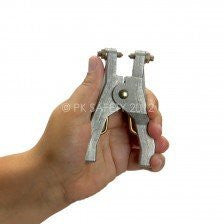 A hand holds the Stewart R. Browne Ground Clamp, REB2960, a vital tool in livestock management for attaching identification tags to animals. This accessory features stainless steel contacts and a rounded tip, enhanced by an ergonomic grip for easy handling.