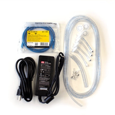 On a white surface, there is an assortment of items including a coiled blue CAT 6 cable, a black power adapter with cords, clear hoses, plastic connectors, and small washers. Among them is the BW IntelliDoX Enabler Kit DX-ENBL-NA from PK Safety Supply for streamlined device management.