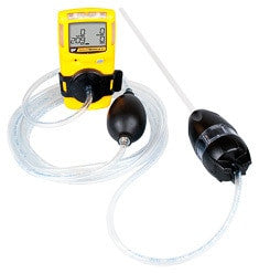 A BW Honeywell GasAlertMicroClip gas detection device in yellow, featuring a digital screen, is linked to the BW Honeywell Manual Aspirator Pump (Model: MC-AS01) using clear tubing. This arrangement leverages cutting-edge gas monitors to efficiently sample and measure gas levels.