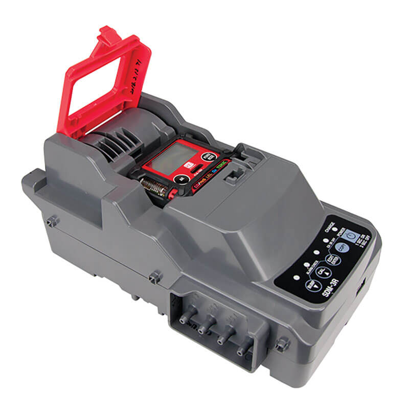 A gray RKI SDM-3R Stand Alone Calibration Station 81-SDM3R101 power tool battery charger, featuring a red handle and digital display, has numerous buttons and indicators on the front panel.