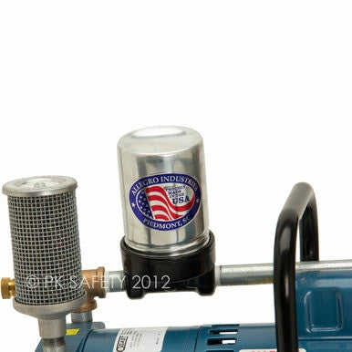 Close-up of a metal cylindrical component, likely part of the Allegro A-750 Ambient Air Pump 9821, with a mesh filter next to it, attached to a larger machine part. The cylinder features a logo with the American flag and the text "Allegro Industries, Piedmont, SC.