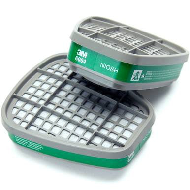 A pair of 3M 6004 Ammonia Methylamine Cartridges, featuring gray ventilated filters and green "NIOSH" labels, provides top-notch respiratory protection for 3M respirators. One cartridge is positioned upright while the other is displayed on its side.