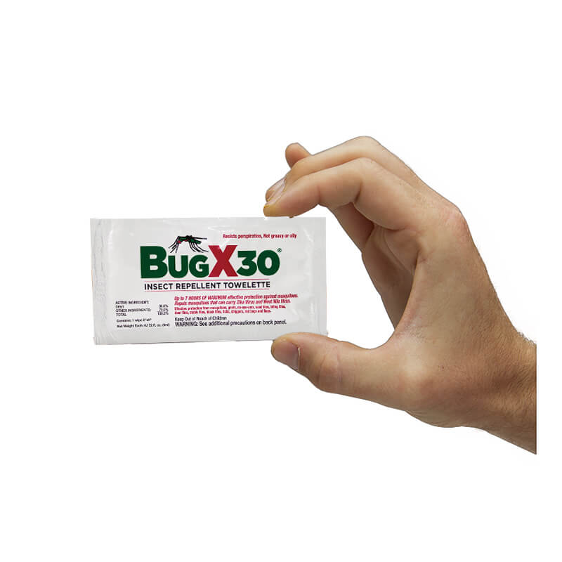 A hand holding a Coretex BugX30 Deet Insect Repellent Towelette, showcasing a protective formula with Deet. The packaging is white with green and red text.