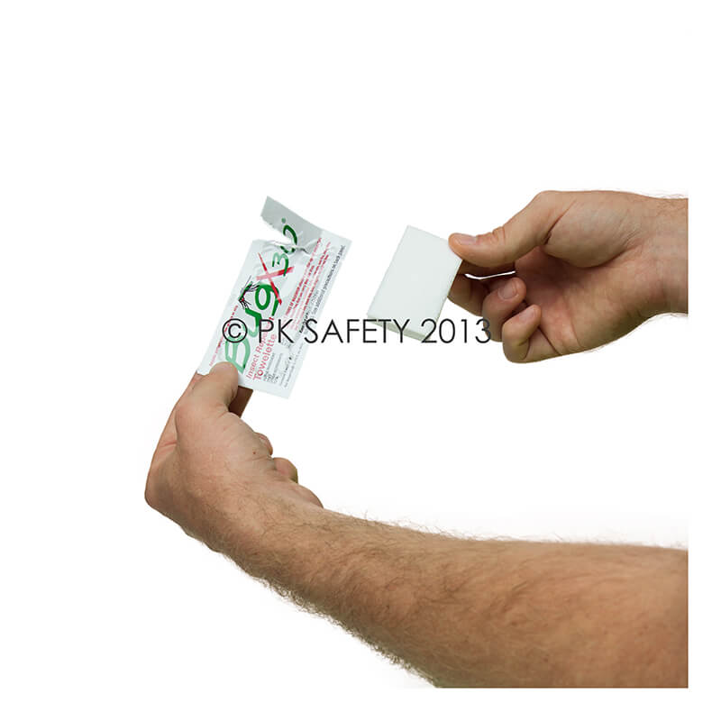 A person tearing open a small packet of a Hydrochloric Acid Spill Clean Up Kit, displaying text and a partially visible red and green symbol reminiscent of the Coretex BugX30 Deet Insect Repellent Towelettes branding. The background is white.