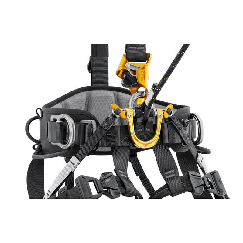The Petzl ASTRO International Harness C083BB0_ features a black and gray design with multiple straps, metal buckles, and a yellow-black attachment point. Enhanced with 3D foam padding, it's ideal for climbing or rope access technicians.