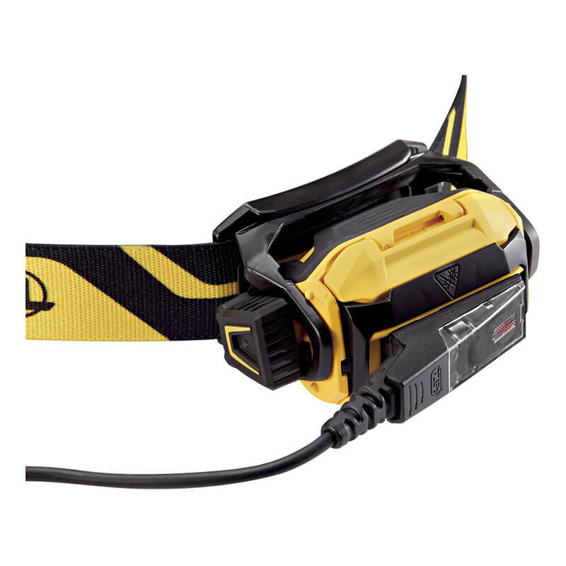 A close-up of the Petzl PIXA R Waterproof, Rechargeable Headlamp E120CA00 by Petzl shows its yellow and black rugged design, adjustable strap, and charging cable plugged into the side.