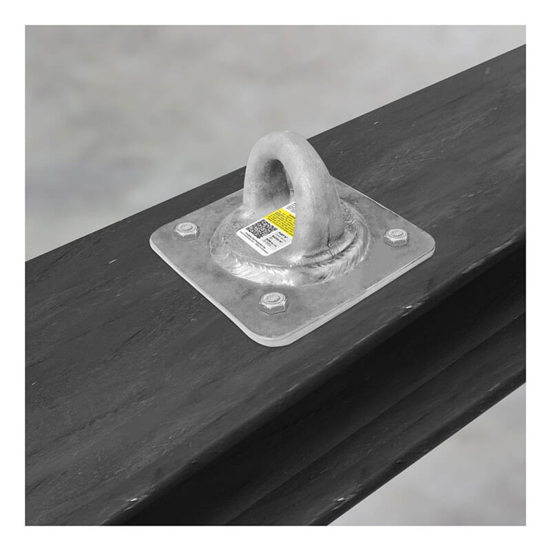 The Frontline Fall Protection Concrete & Steel 10K HDG Reusable Anchor Plate with a D-ring is bolted to a steel beam for fall arrest. A label with barcode and text is attached. Suitable for concrete and steel structures; background is blurred.