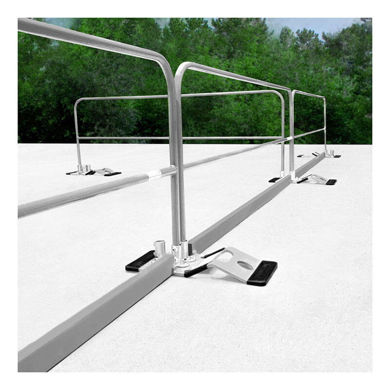 A galvanized Frontline 10' Guardrail Toe Board GUTO from Frontline Fall Protection is installed on a flat white roof with black weighted bases, providing OSHA-compliant safety and visibility against a backdrop of green trees.