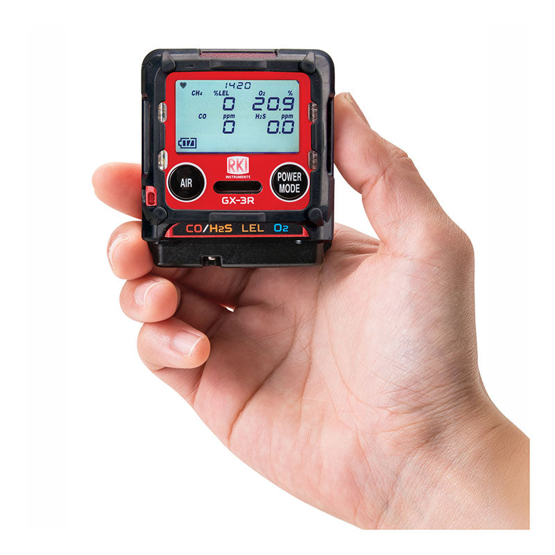 A hand holds the RKI Instruments GX-3R 4 Gas Confined Space Monitor 72-RA-C, featuring a red and black casing and displaying CO/H2S, LEL, and O2 readings—a compact, reliable device for essential gas detection.