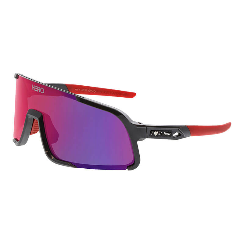 The MCR Safety Hulk HK4 St. Jude HERO Edition Safety Glasses feature a sporty black/red wraparound frame, reflective purple-red lenses, "HERO" branding, and an "I ♥ St. Jude" logo on the temple arm for style and a secure fit.