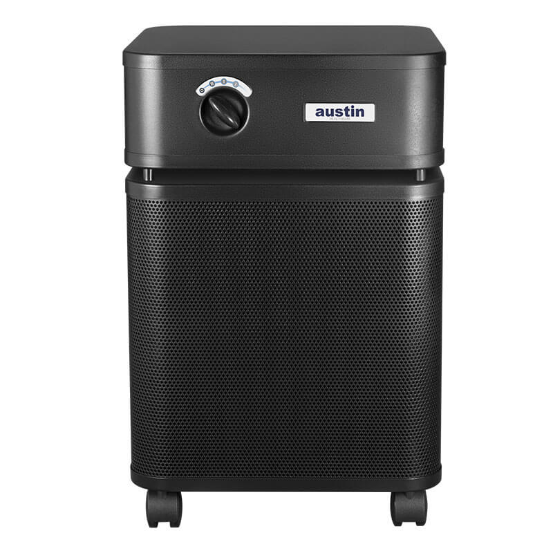 A black Austin Air Systems HealthMate Plus Machine B450 air purifier with a control dial, small wheels, and a perforated front panel featuring medical grade HEPA filtration is displayed against a white background.