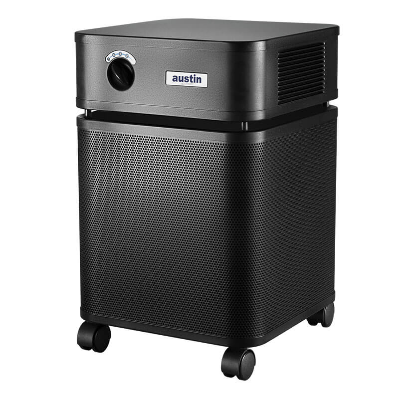 The Austin Air Systems HealthMate Plus Machine B450 in black features a control knob, air vents, four wheels for mobility, and medical grade HEPA filtration for effective formaldehyde removal—ideal for home or office use.