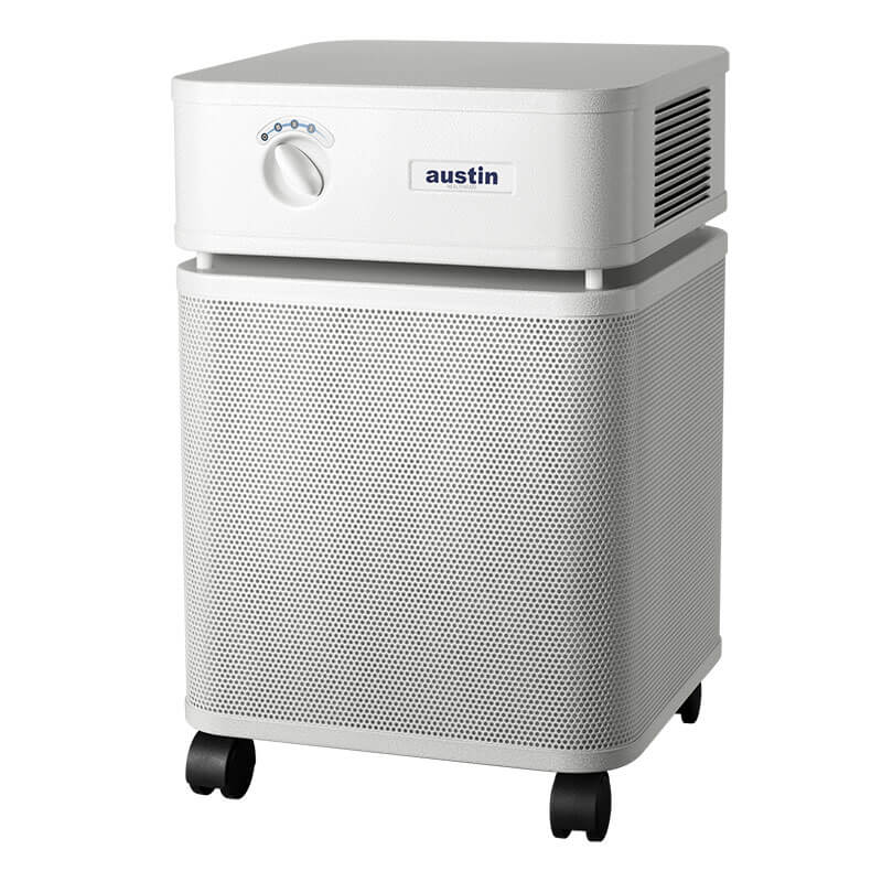 The Austin Air Systems HealthMate Plus Machine B450 is a white air purifier with a square top, control dial, mesh front grille with "austin" branding, side vent, HEPA filtration for formaldehyde removal, and four black caster wheels.
