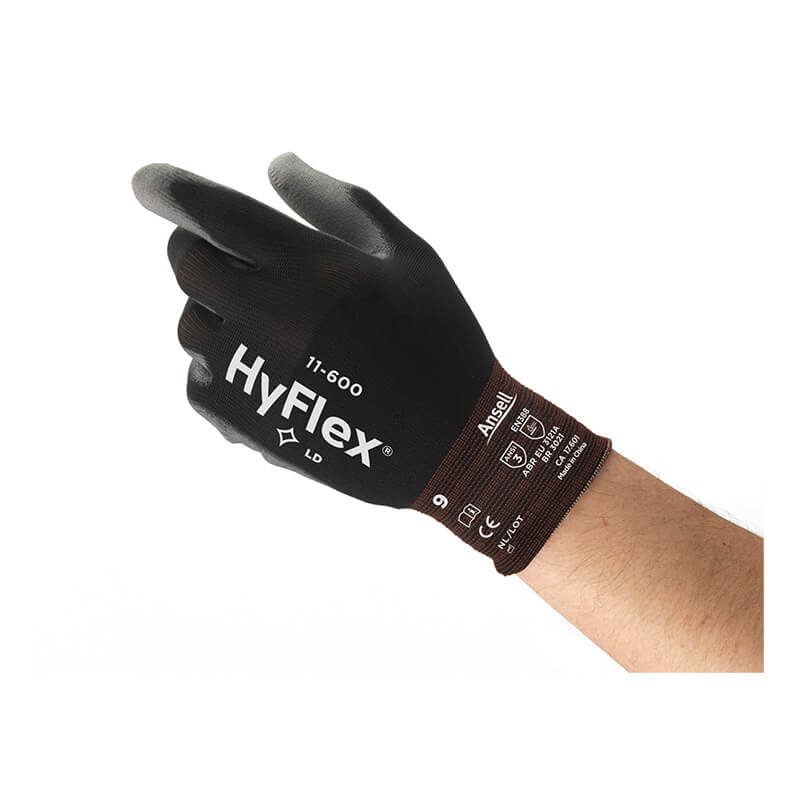 A hand wearing a black Ansell HyFlex Polyurethane Coated Glove 11-600 from Ansell, which features a nylon knit liner and displays safety certifications on the wrist, is shown against a white background.