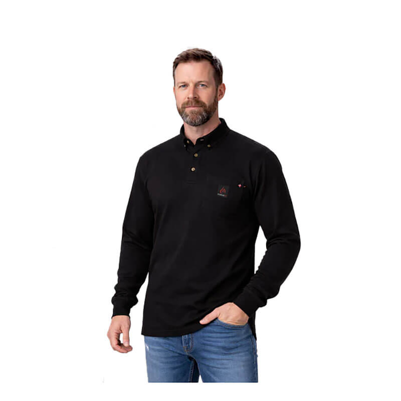 A man with a beard wears the ForgeFR Forge FR Henley MFRHNLY-004, a black, long-sleeve, button-up shirt, along with blue jeans, standing against a plain white background.
