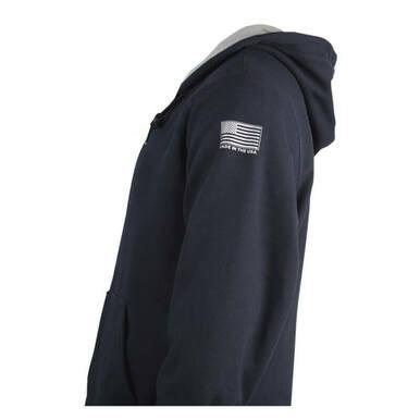A person wearing a navy NSA TECGEN FR Lined Pullover Hoodie with the hood down. The sleeve features a small American flag design alongside the words "Made in the USA." This flame-resistant hoodie by NSA has an arc rating of 39 cal/cm² and offers a relaxed fit, captured from a side angle.