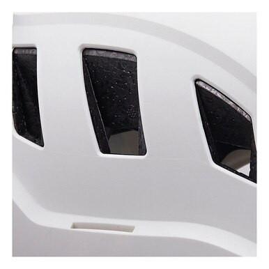 Close-up view of a Petzl STRATO VENT Helmet A020BA0 in white, featuring black ventilation slits with a mesh pattern for optimal airflow. This helmet, designed by Petzl for climbing professionals, offers a customizable fit to ensure comfort and safety. Its smooth and slightly curved surface makes it ideal for technical rescue scenarios.