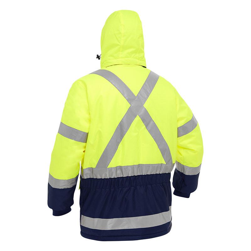 A person wearing the PIP Bisley X-Back Extreme Cold Jacket w/Navy Bottom 343M6450X, featuring a bright yellow color, silver reflective stripes, hood, and navy lower sleeves and hem for enhanced visibility and safety.