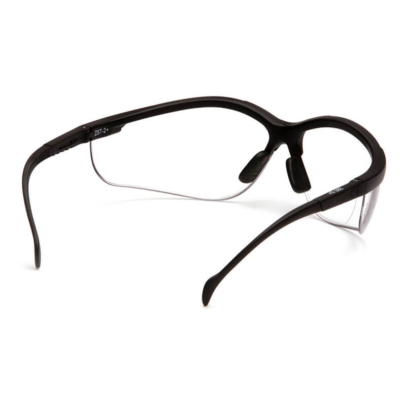 Introducing the Pyramex Venture II V2 Reader Safety Glasses from Pyramex Safety, featuring black frames with wraparound design and transparent lenses. These bifocal glasses are equipped with cushioned nose pads and sleek, curved arms to provide both comfort and style. They meet OSHA ANSI Z87.1 standards for eye protection, ensuring safety without compromising on appearance.