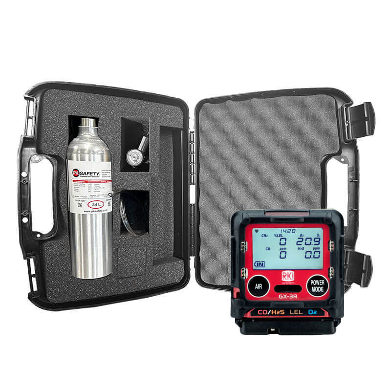 The PK Safety RKI GX-3R Bundle includes a black hard case with foam padding holding a metal gas cylinder, regulator, tubing, and the RKI GX-3R Gas Monitor, which displays air quality data and features several labeled buttons.