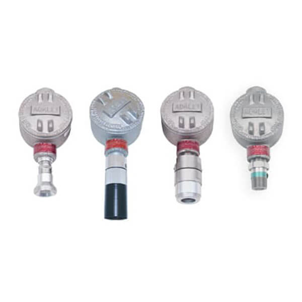 Four RKI Instruments S2 Fixed Gas Sensors/Transmitters, featuring a metal design with round tops, cylindrical connectors, and explosion-proof construction, are arranged in a row against a white background.