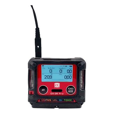 The RKI GX-3R Pro 5 Gas Confined Space Monitor with Wireless Communication from PK Safety Supply is a portable device encased in red and black. It features a screen displaying numerical readings, ideal for personal monitoring. Equipped with a charging cable connected at the top, it offers convenience and reliability on the go.