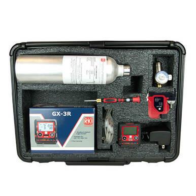 The RKI GX-3R 4 Gas Confined Space Kit is a precision instrument set designed for use in tight spaces, encased in a foam-lined black case. The kit comes with a metal cylinder, digital devices, cables, and a screwdriver. It is specifically designed for detecting four different gases, and the inside of the case lid includes a printed manual or brochure on the left side.