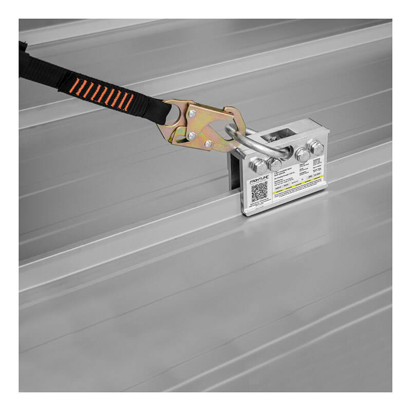 A close-up of the Frontline Fall Protection Frontline 2-Way Standing Seam Roof Anchor RO2W, featuring a non-penetrating design attached to a standing seam metal roof with a black and orange safety strap connected to the anchor point.