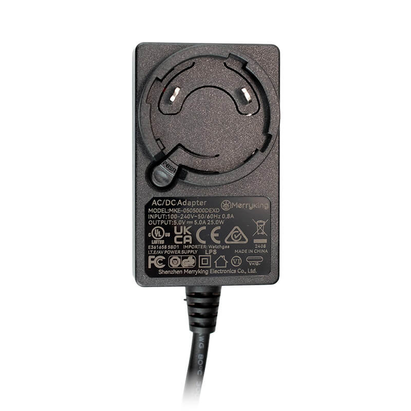 The WatchGas SST 6 Way Bench Top Charger (SST-6WSCC-KIT) by WatchGas is a black AC/DC power adapter with technical specifications and certification logos displayed on the front. Designed as part of a centralized charging solution, it features a circular connector holder and a cable extending from the bottom, making it ideal for efficient six-device charging with the SST Range 6-Way Charger systems.