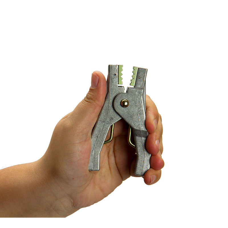 A hand holds a Stewart R. Browne Aircraft Grounding Clamp ALS10A, a heavy-duty aluminum grounding pliers with serrated jaws and gripping mechanism, shown against a plain white background.