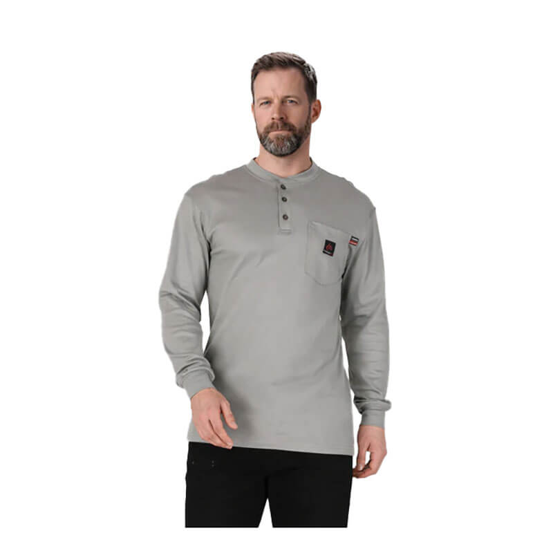 A man with short hair and a beard wears the ForgeFR Forge FR Henley MFRHNLY-004, an NFPA 2112-compliant flame resistant shirt with a buttoned placket and chest pocket, standing against a plain white background.