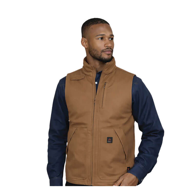 A man models the ForgeFR Forge FR Canvas Duck Vest MFRVST-001 in brown over a dark blue shirt, standing against a plain white background with a neutral expression, showcasing classic workwear style.