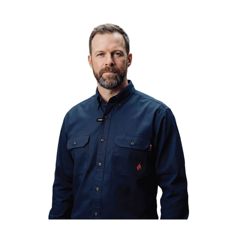 A man with short hair and a beard wears the ForgeFR Forge FR Solid Button Shirt MFRLB2PS024, NFPA 2112 compliant, in navy blue, standing against a plain white background and facing the camera with a neutral expression.