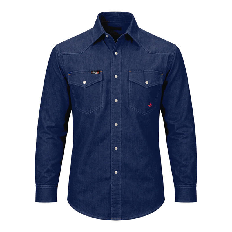 The ForgeFR Solid Shirt Denim MFRSLD-002 from ForgeFR embodies a classic workwear style with its blue denim design, two chest pockets, and white buttons. The shirt features visible stitching and is set against a plain white background, delivering a timeless look that seamlessly complements any flame-resistant clothing collection.