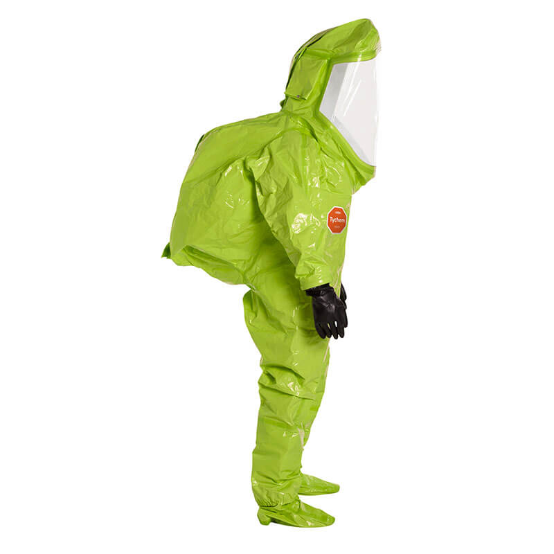 A person in a bright green Dupont Tychem 10000 Commander EX Level A Suit TK555T with a clear face shield, black gloves, and covered shoes stands in profile view against a white background.