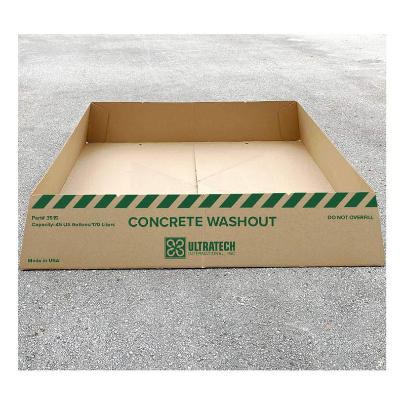 A large, rectangular cardboard container labeled "UltraTech Concrete Washout Berms - Economy Model 351" sits on a gray surface. It features green stripes and text, highlighting its 45 US gallons/170 liters capacity. The brand name "UltraTech" ensures EPA regulations compliance with portable berm options.