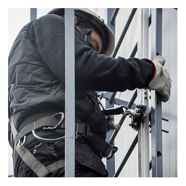 A person in safety gear and helmet climbs a structure-mounted roof access ladder, using the Frontline Securail Pro Vertical Lifeline System VLRS with harness from Frontline Fall Protection for fall arrest.