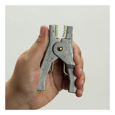 A hand holds a Stewart R. Browne Aircraft Grounding Clamp ALS10A, a heavy-duty aluminum grounding pliers with serrated jaws and gripping mechanism, shown against a plain white background.