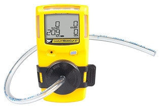 A yellow GasAlert MicroClip portable gas detector, featuring a digital screen displaying numbers and a black protective cover, comes equipped with the BW Honeywell GasAlertMicroClip Replacement Test Cap and Hose (1ft/3m) MC-TC-1 for calibration.