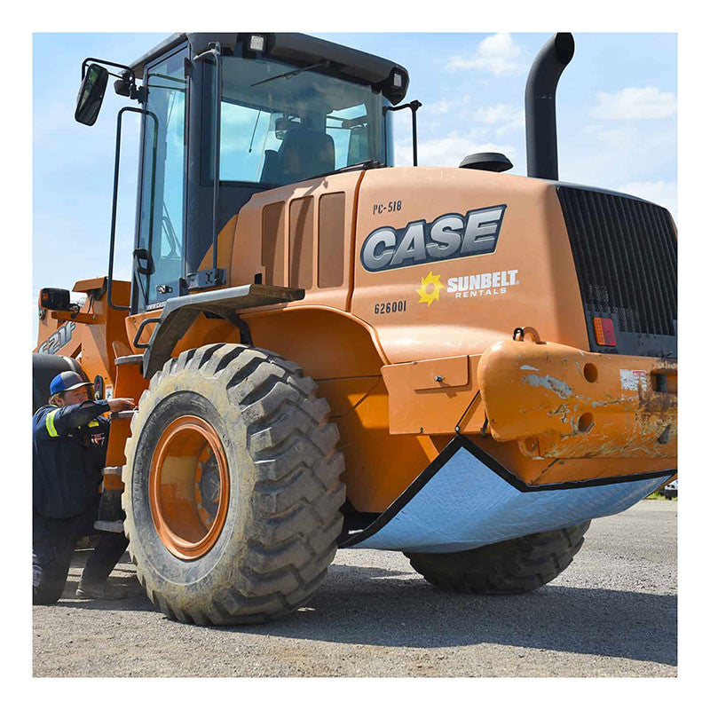 A large orange construction vehicle branded with "CASE" and "Sunbelt Rentals" is parked on a gravel surface. A person in a safety helmet inspects the vehicle's front wheel to ensure that the UltraTech Spill Diaper 0275, from UltraTech International, Inc., is effectively providing spill containment. The scene is complemented by a clear blue sky backdrop.