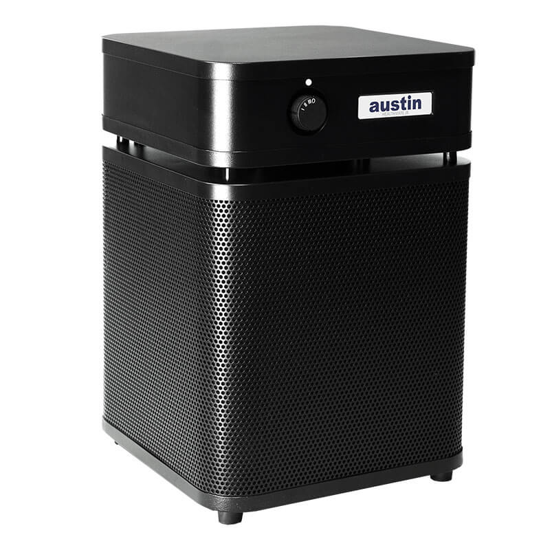 The Austin Air Systems HealthMate Junior Machine A200, a black HEPA air purifier with a square top, control knob, and perforated front panel for air intake, is ideal for allergies and stands on small feet against a white background.