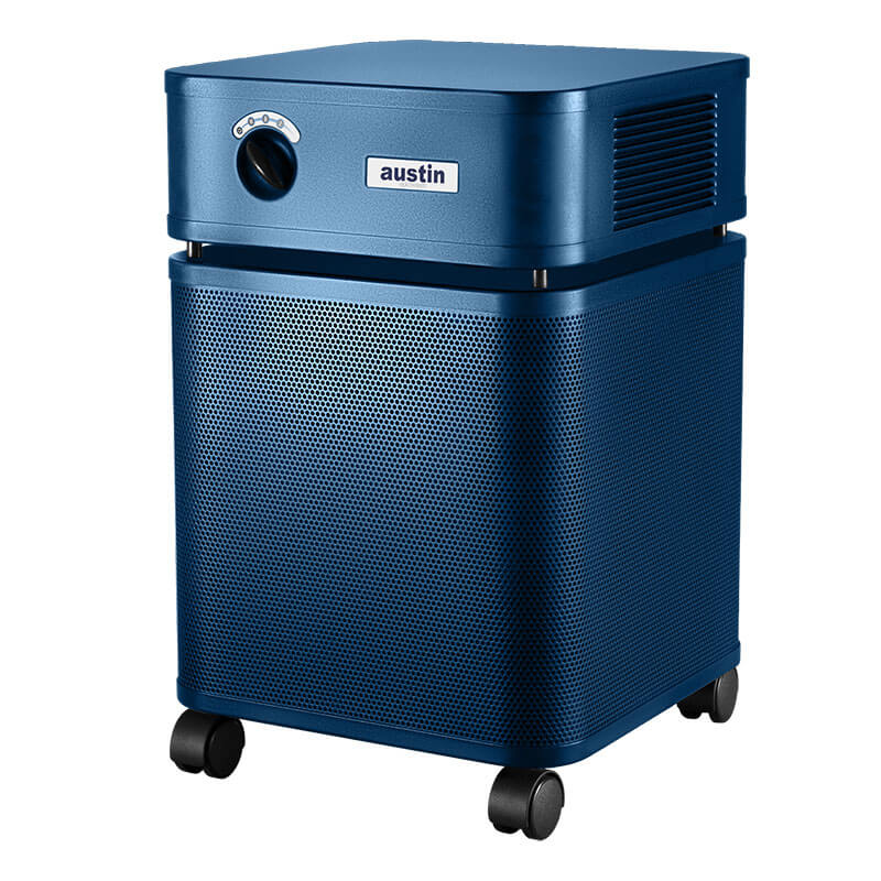 A blue rectangular Austin Air Systems HealthMate Plus Machine B450 air purifier with a control knob, air vents, and "austin" branding on top. It features medical-grade HEPA for formaldehyde removal, perforated panels, and four black caster wheels.