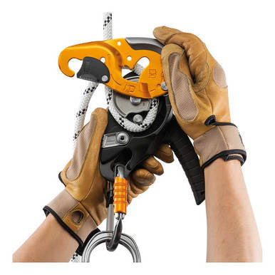 Wearing brown gloves, a person adjusts a safety device on a climbing rope, crucial for rope access work. This essential tool is the Petzl I'D S Descender Self-Braking D020AA00, which features an orange hook and black handle, ensuring secure ascents and descents.