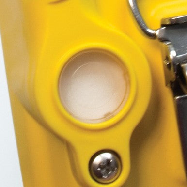 Close-up of a yellow object with a circular opening and a metal component on the side, resembling the compact design of the BW Honeywell Hydrophobic Pump Filter Replacements XT-RF-H50 from PK Safety Supply, featuring a visible screw at the bottom of the opening.