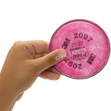 A hand holds a 3M 2097 P100 Particulate / Organic Vapor Filter (Pair) by 3M, round and pink, widely used for effective respiratory protection during mold remediation.