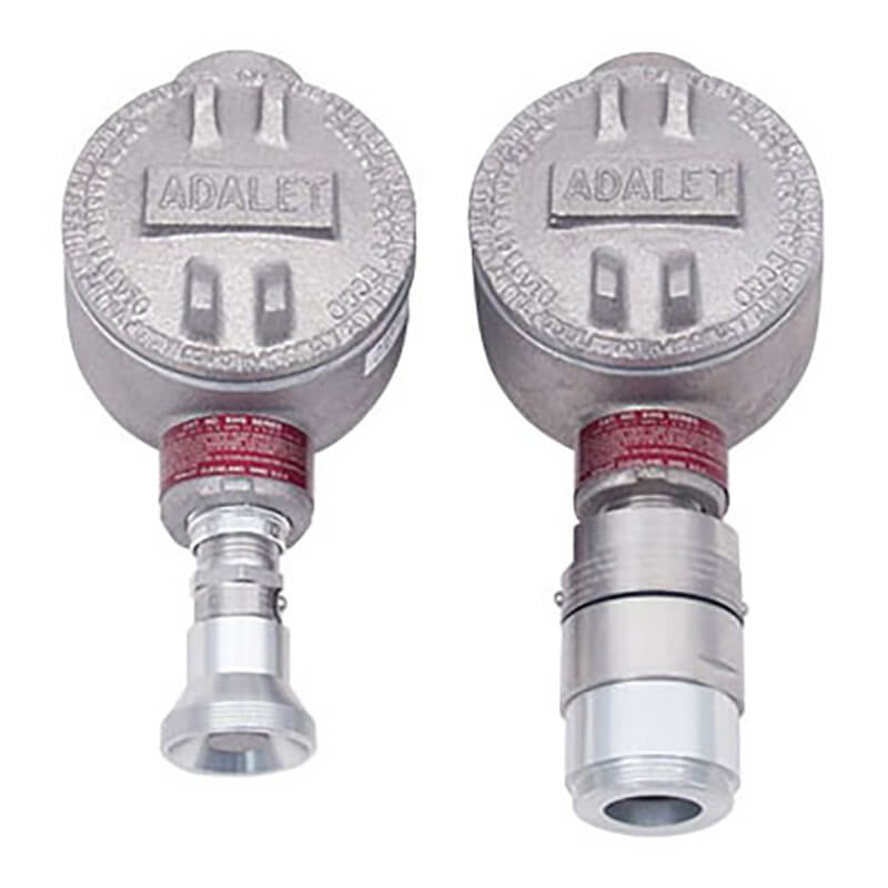 The RKI Direct Connect Gas Sensor LEL, H2 Specific features two industrial metal enclosures prominently branded with "RKI Instruments" on top. These enclosures have cylindrical bases and connectors for securely attaching equipment. Their explosion-proof design ensures safety when used in environments containing toxic gases. Additionally, they exhibit a rugged, metallic finish.